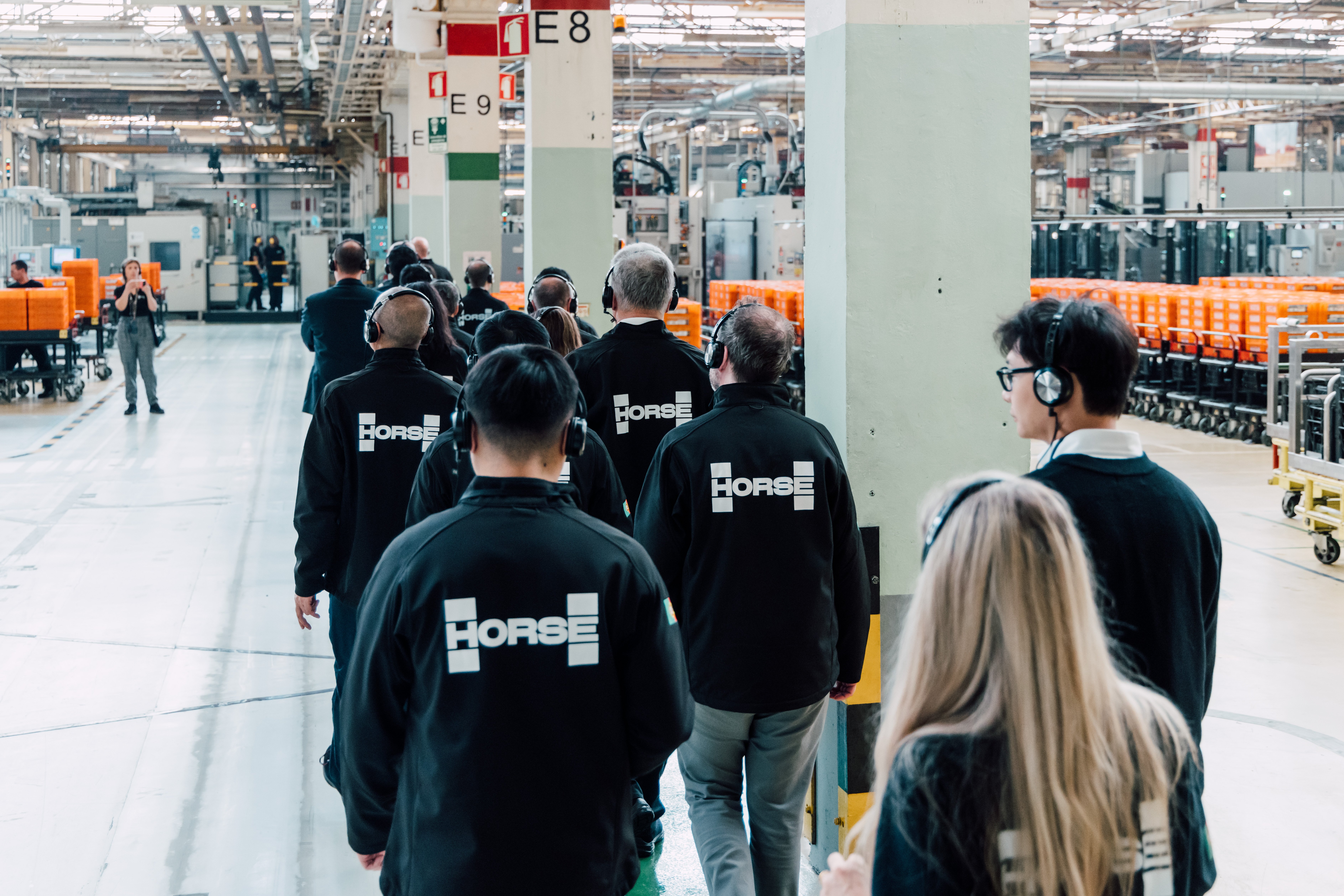 Horse Powertrain jacket-wearing people on a tour of a company plant