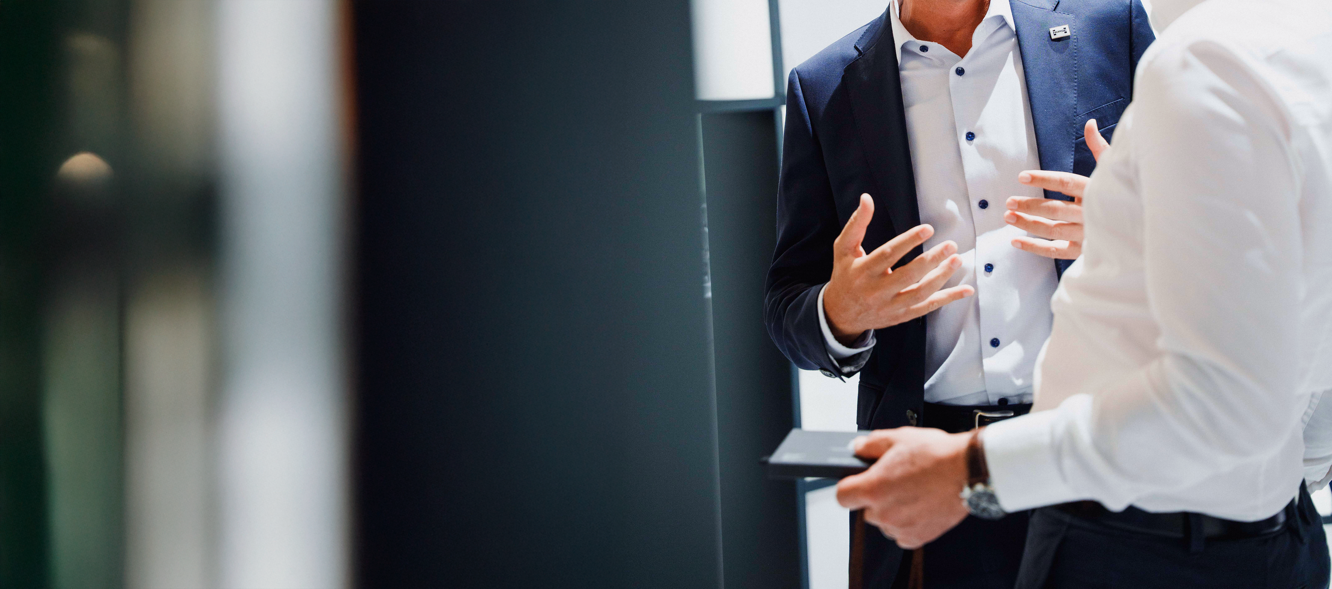 Two persons in suits talking to each other at a fair
