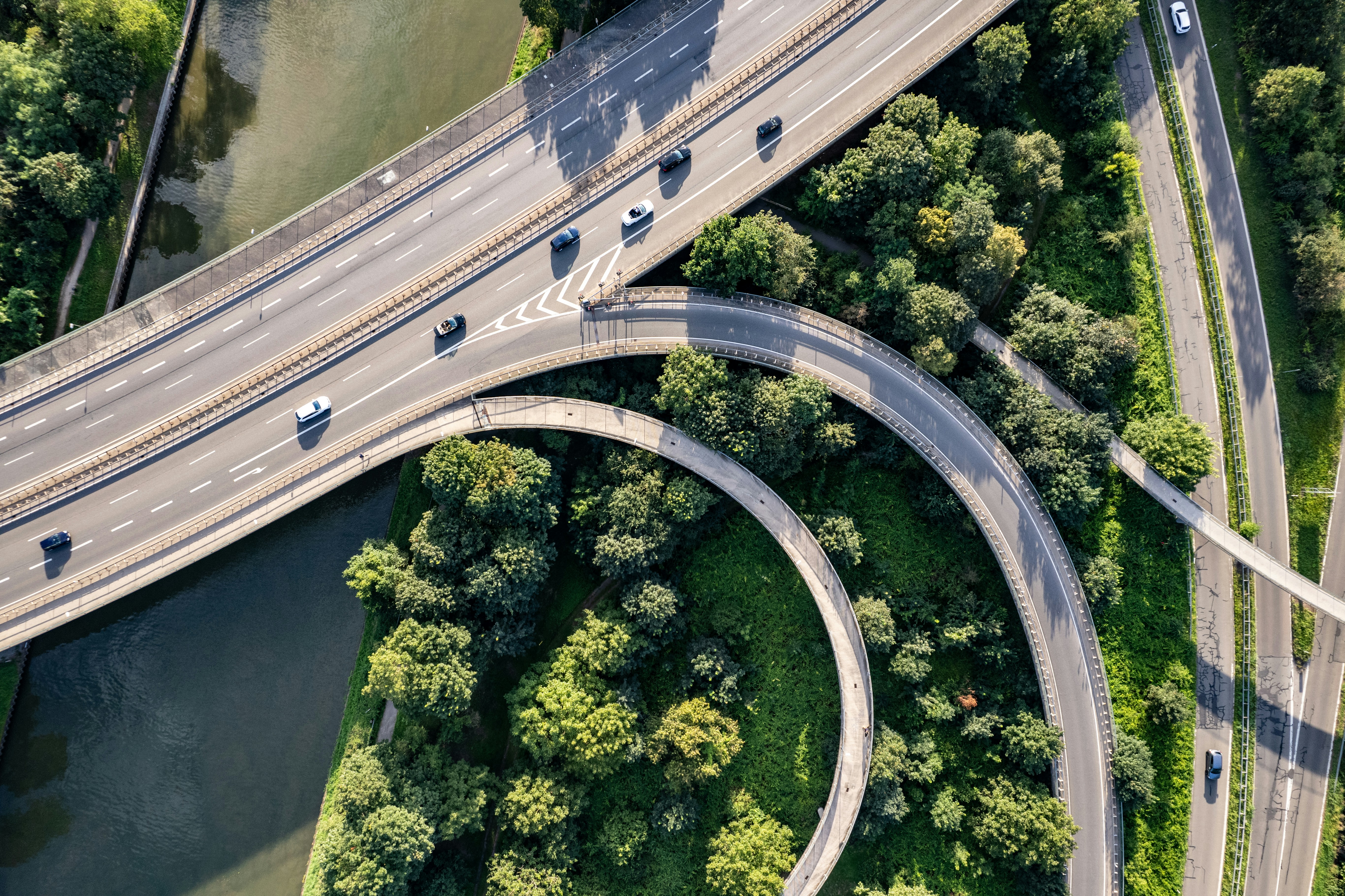 Aerial view of a motorway junction system and several cars driving along them