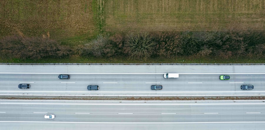 An aerial view of a motorway alongside a green field