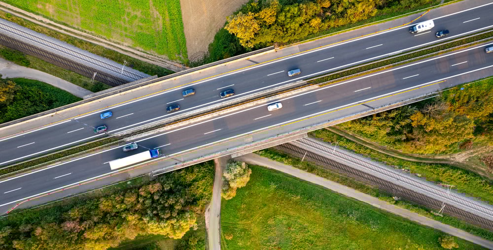 A motorway crossing over rural paths and a train track