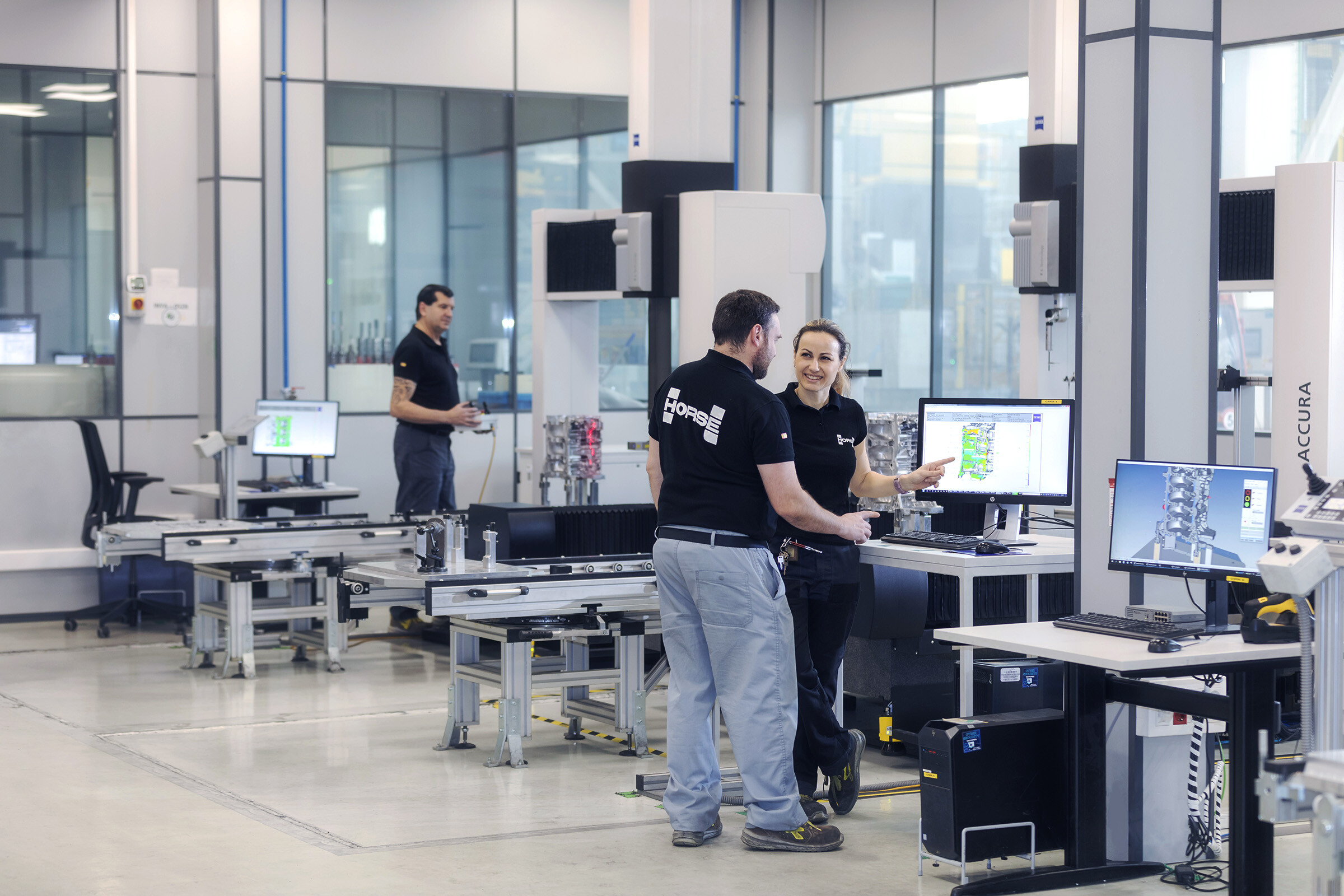 a man and a woman is working togheter in front of a computer in a clean factory environment