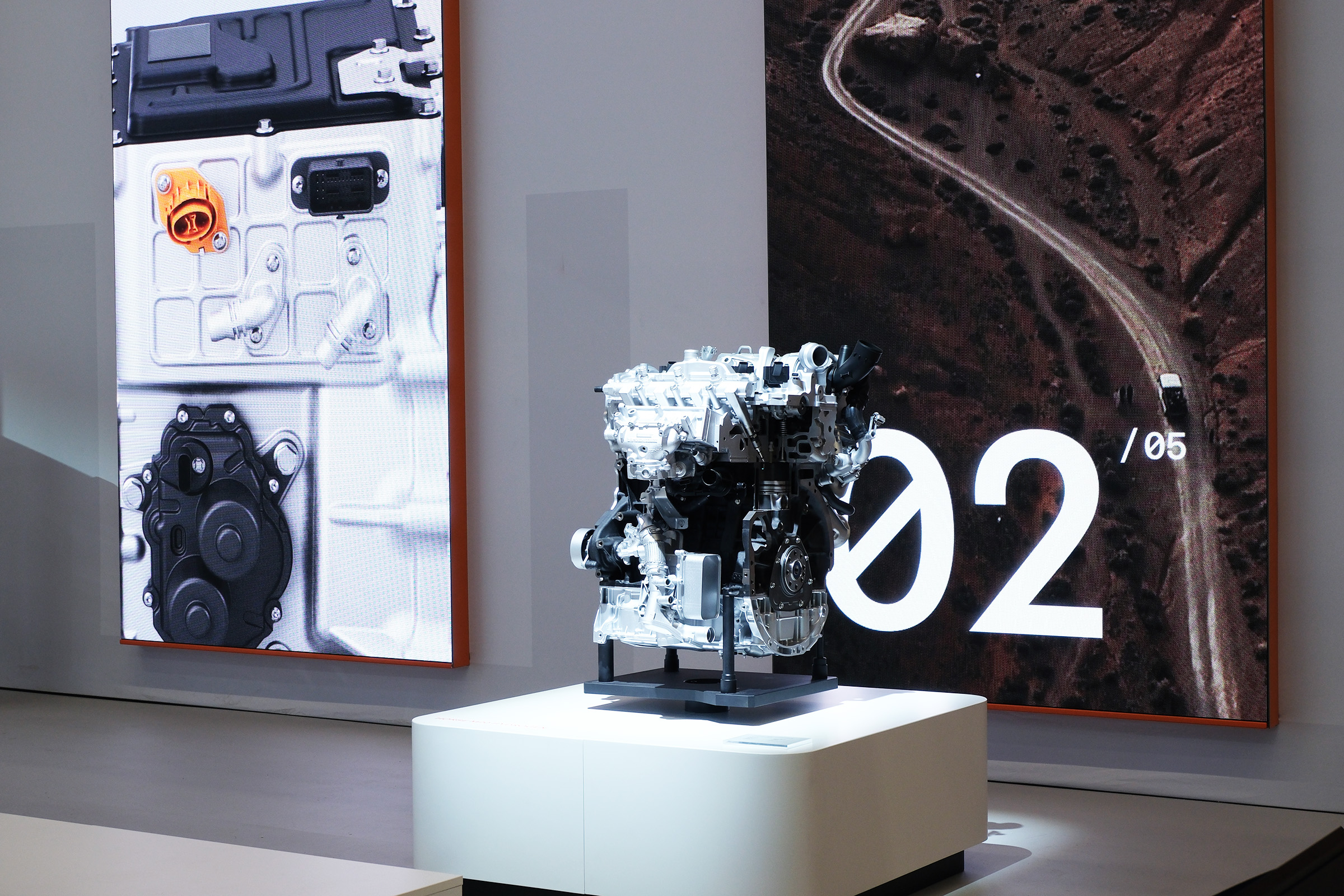 An engine on a podium with decorative screens in the background at IAA summit 2025.