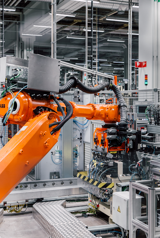 An orange robot is working in an engine factory of Horse Powertrain